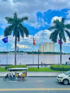 Phnom Penh riverside promenade with tuk tuk and palm trees