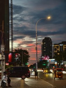 Evening street scene in Phnom Penh with tuk tuk traffic